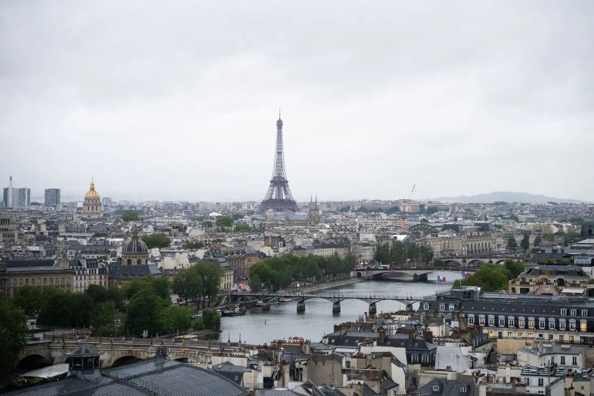 Overcast aerial view of Paris skyline with Eiffel Tower, Seine river and bridges.