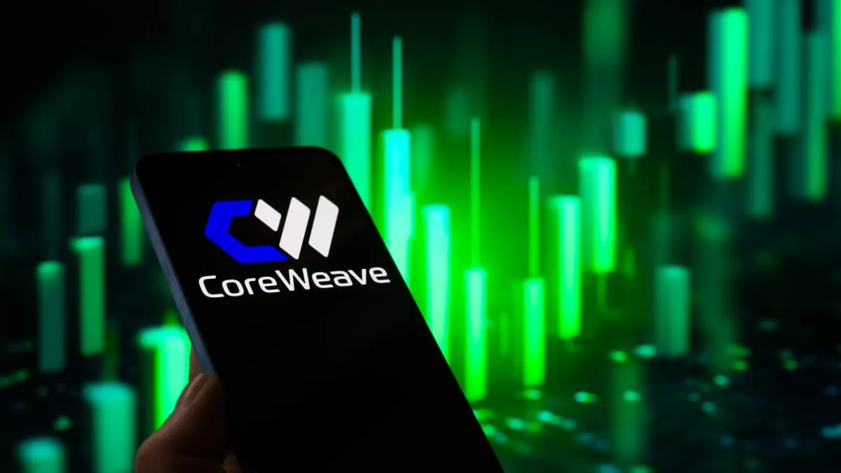 Hand holding phone showing CoreWeave logo in front of glowing green stock chart graphic