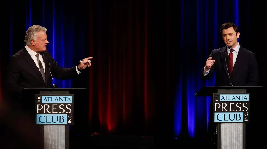 Two men in suits gesture at each other behind podiums at a debate stage.