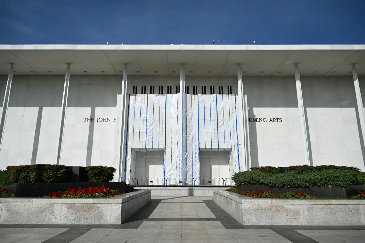 Facade of the John F. Kennedy Center for the Performing Arts, partly covered with white and blue fabric.