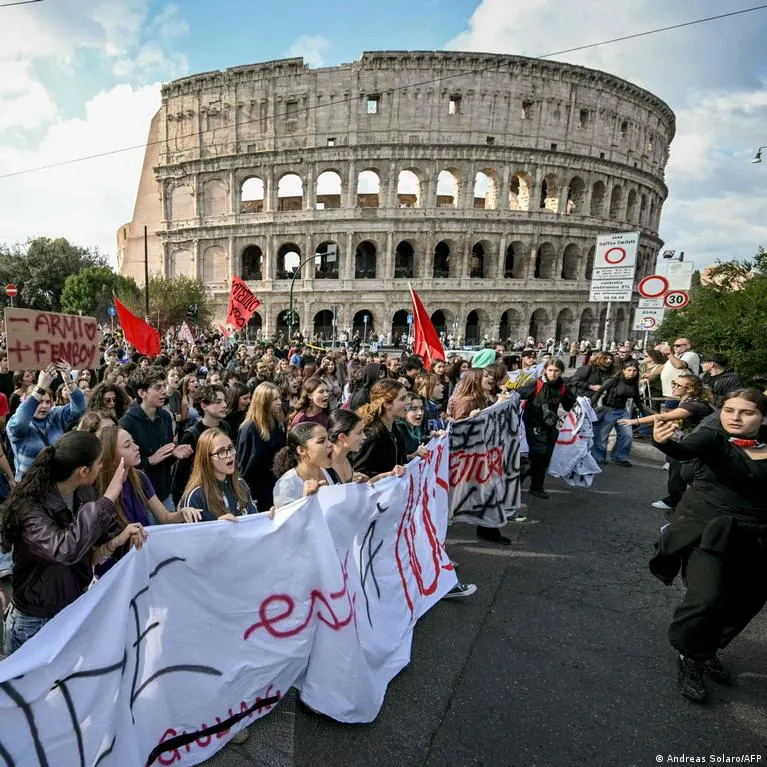 Students with hand-painted banners and placards march past the Colosseum in Rome.