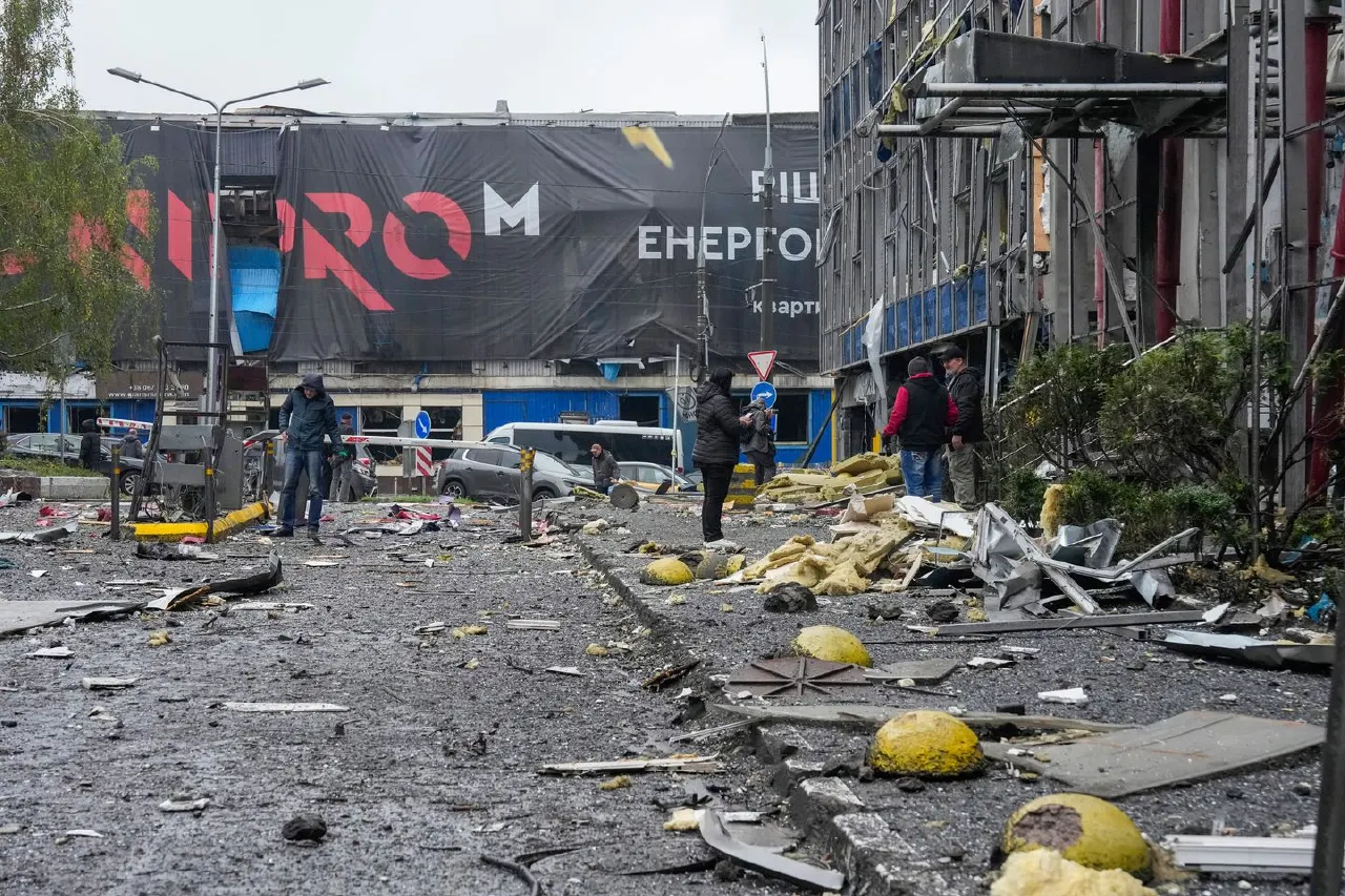 Debris-strewn street after strike, damaged building, yellow debris, people standing among wreckage