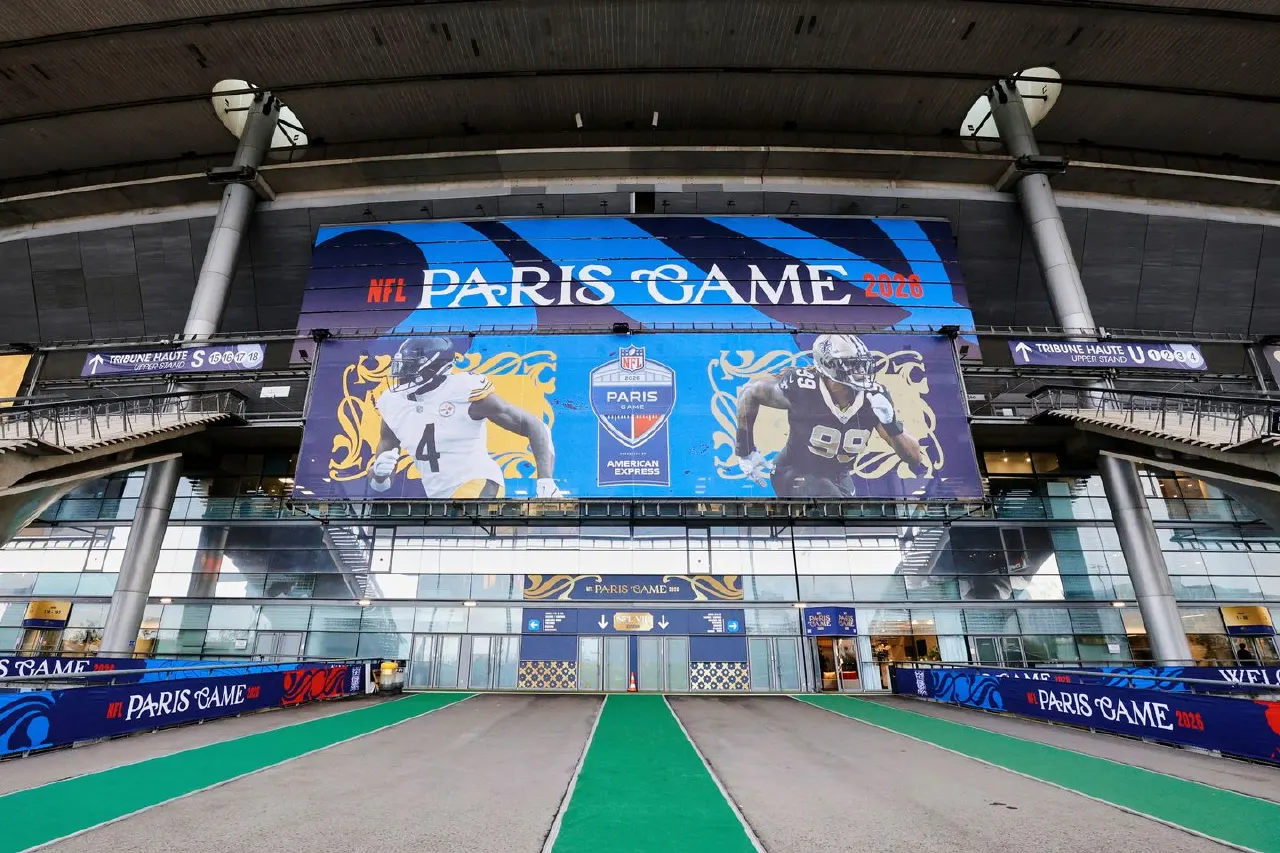 Stadium entrance with large NFL Paris Game banner and player images, green turf walkway