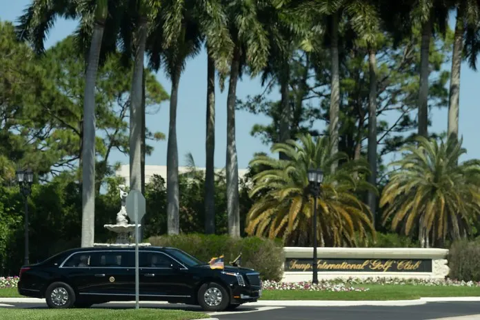 Trump International Golf Club entrance with palm trees and ornate sign visible.