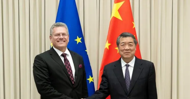 Two men in suits shake hands in front of EU and Chinese flags.
