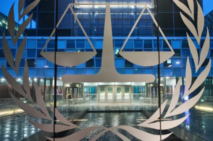 Glass entrance of a court building with scales of justice and laurel emblem overlay