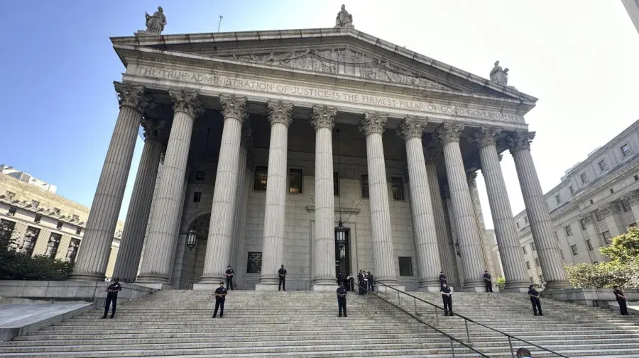 Neoclassical courthouse columns and steps with uniformed officers standing guard outside.