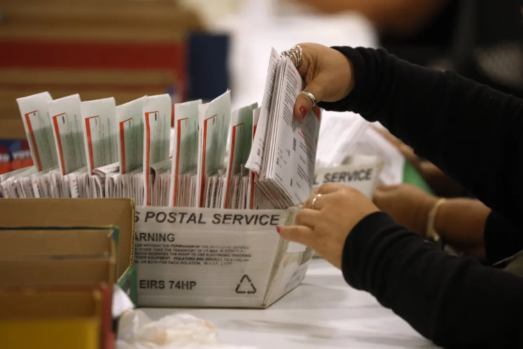 Election workers sorting mail ballot envelopes from a U.S. Postal Service box