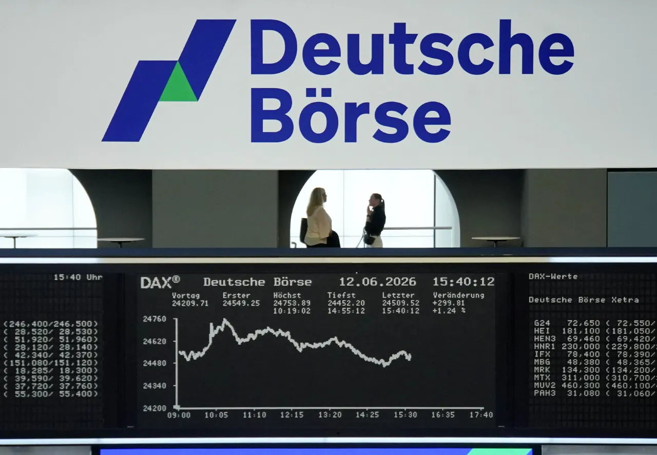 Deutsche Börse exchange hall with DAX stock ticker display and two people in background.