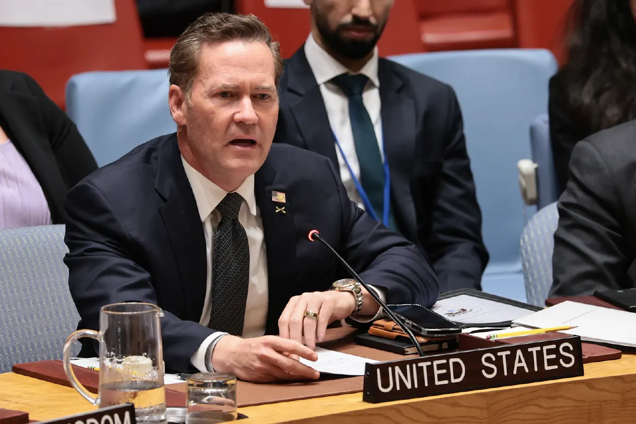 Man in dark suit speaks at UN Security Council table with United States nameplate.