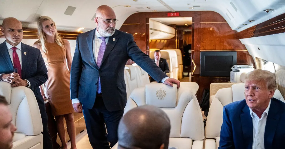 Men and a woman standing and seated inside a luxury private jet cabin with cream leather seats.