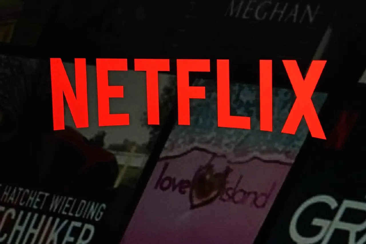 Red Netflix logo displayed over dark streaming show thumbnails on a screen