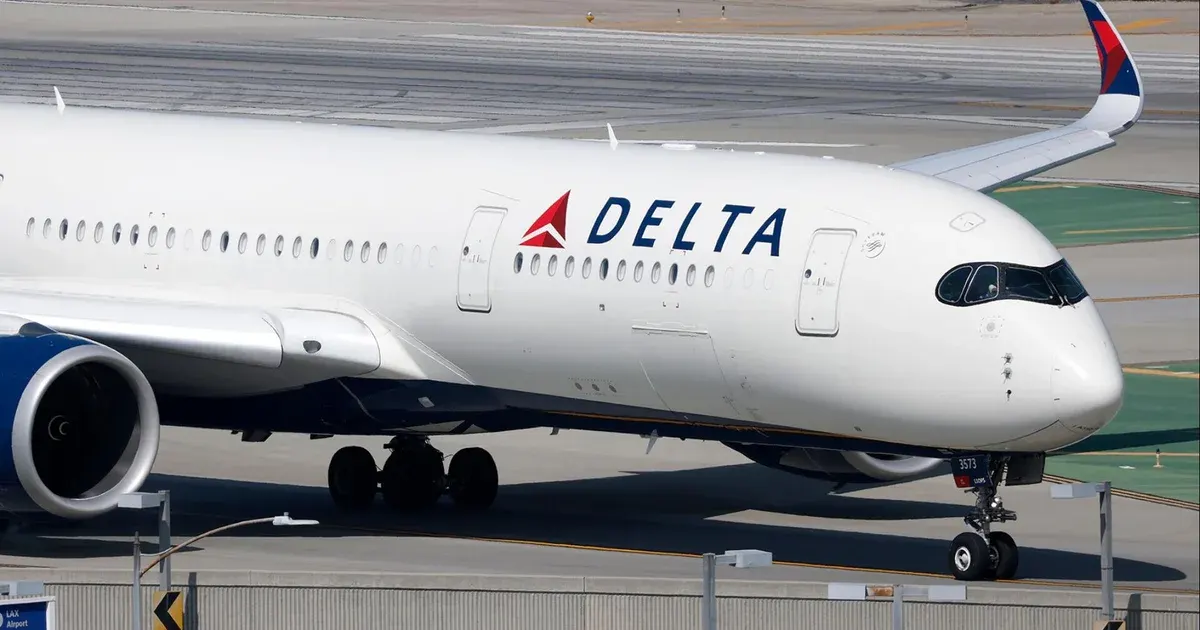 Delta Air Lines jet taxiing on airport tarmac, Delta logo visible on fuselage.
