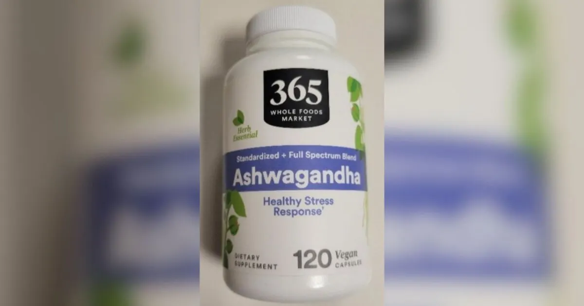 White supplement bottle labeled 365 Whole Foods Market Ashwagandha capsules, 120 count, on blurred background.