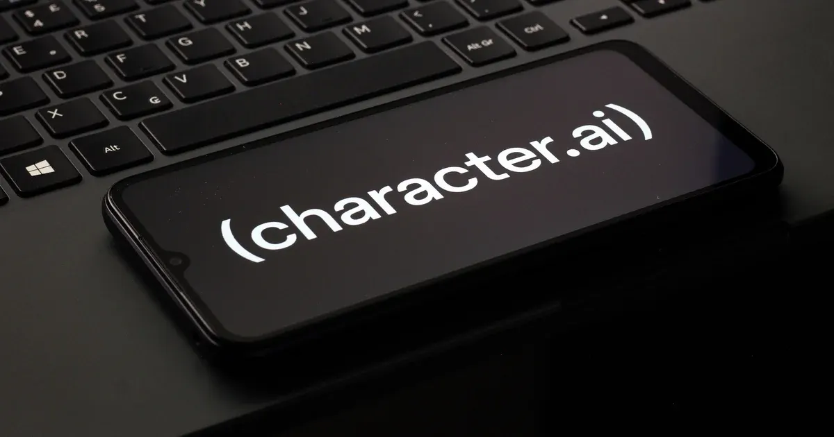 Smartphone on a laptop keyboard displaying the Character.AI logo on a black screen