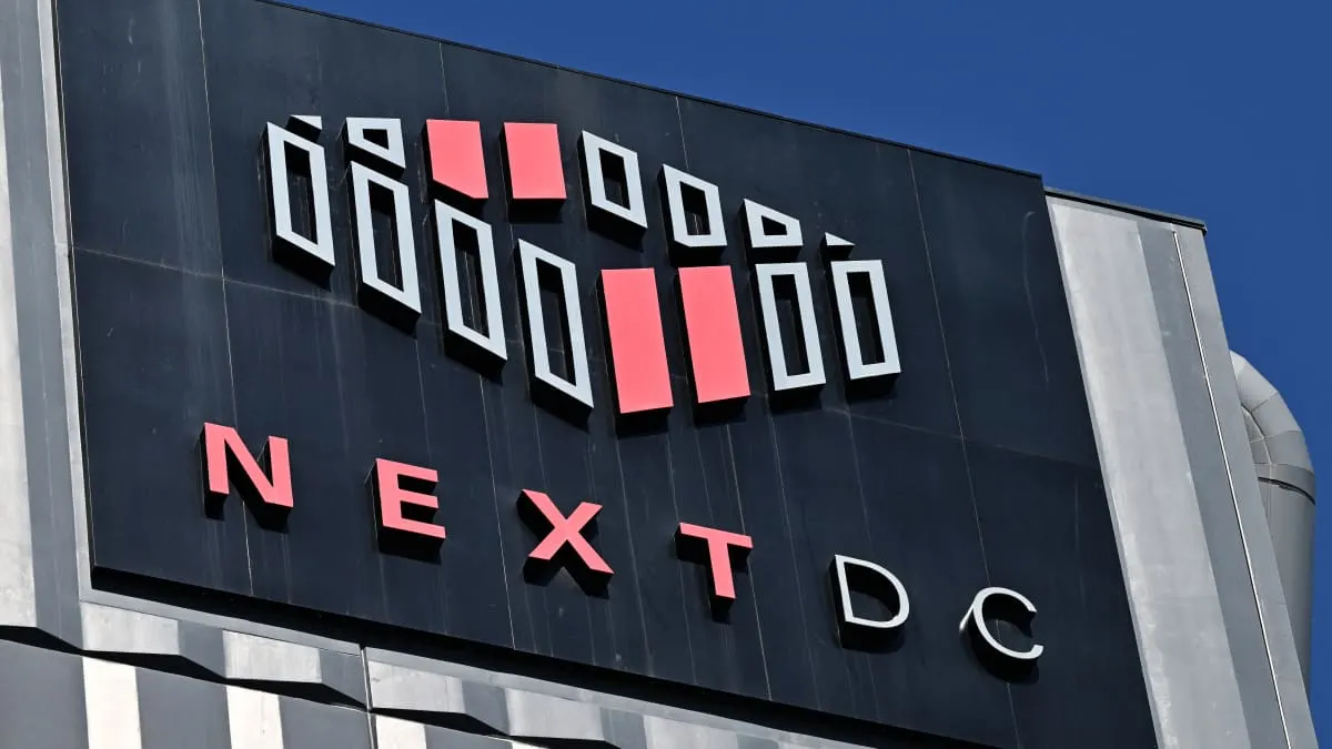 NextDC logo and name on a dark building facade against blue sky