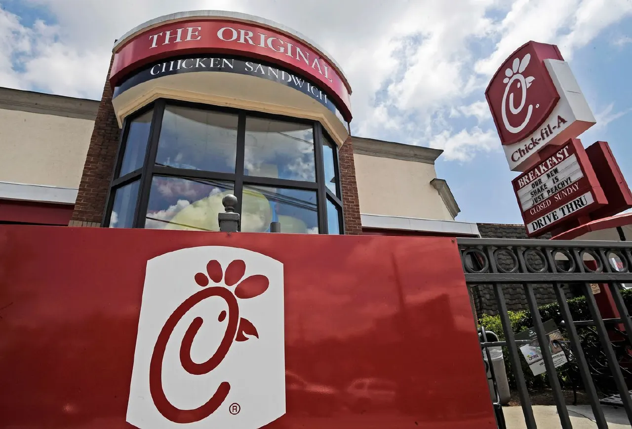 Chick-fil-A restaurant exterior with cow logo sign and drive-thru signage