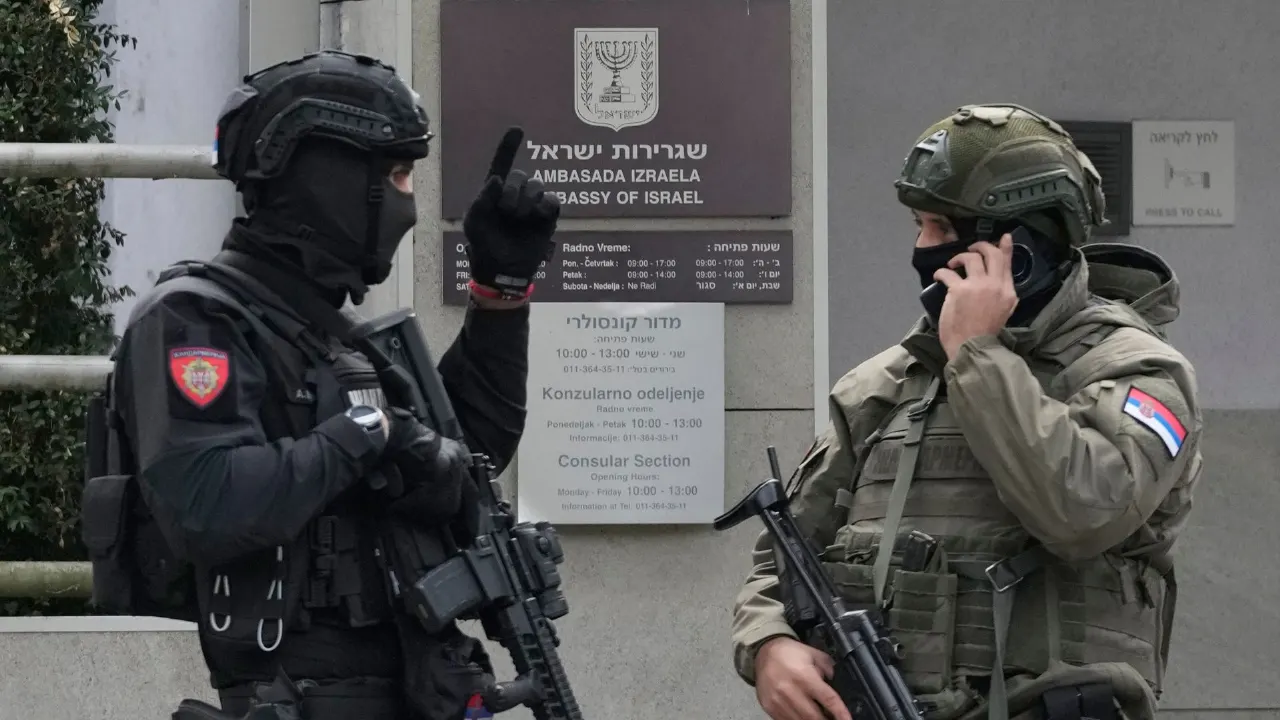 Two armed police officers in tactical gear outside the Israeli Embassy building in Belgrade.