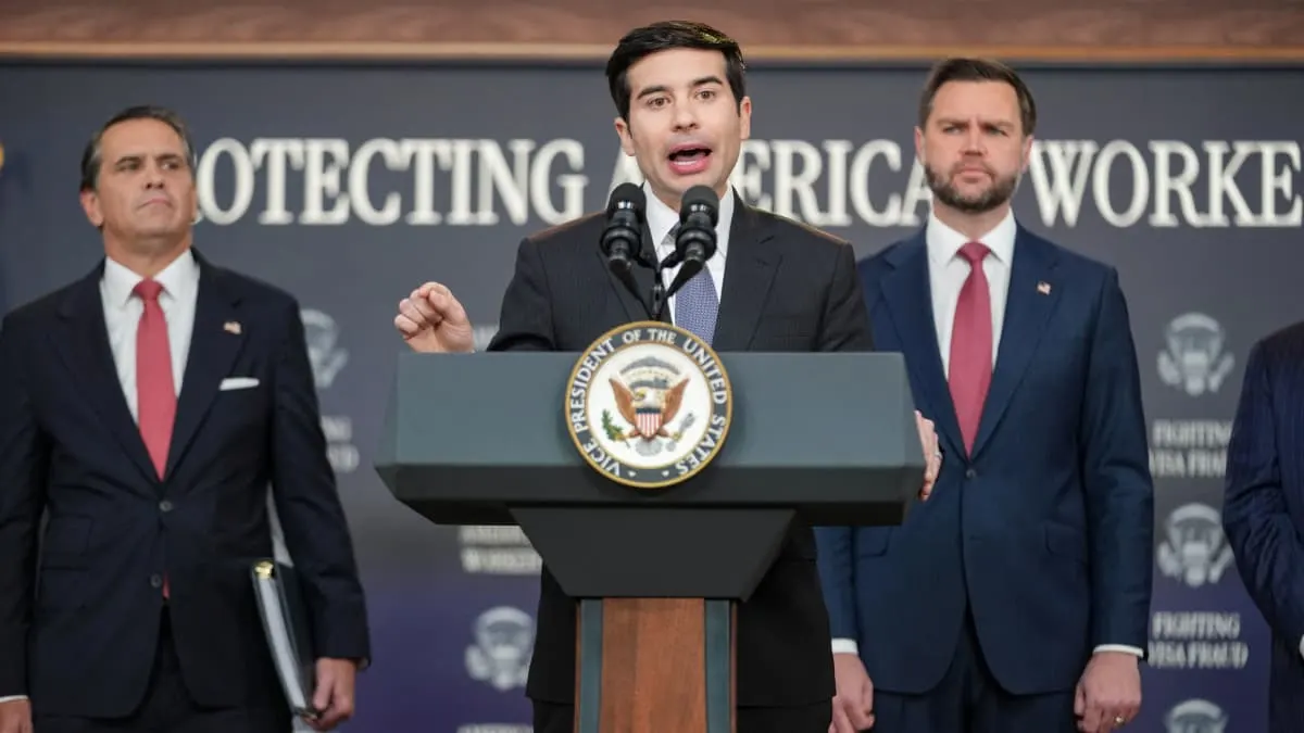 Man speaking at a podium bearing the Vice President seal, backdrop reads Protecting American Workers.