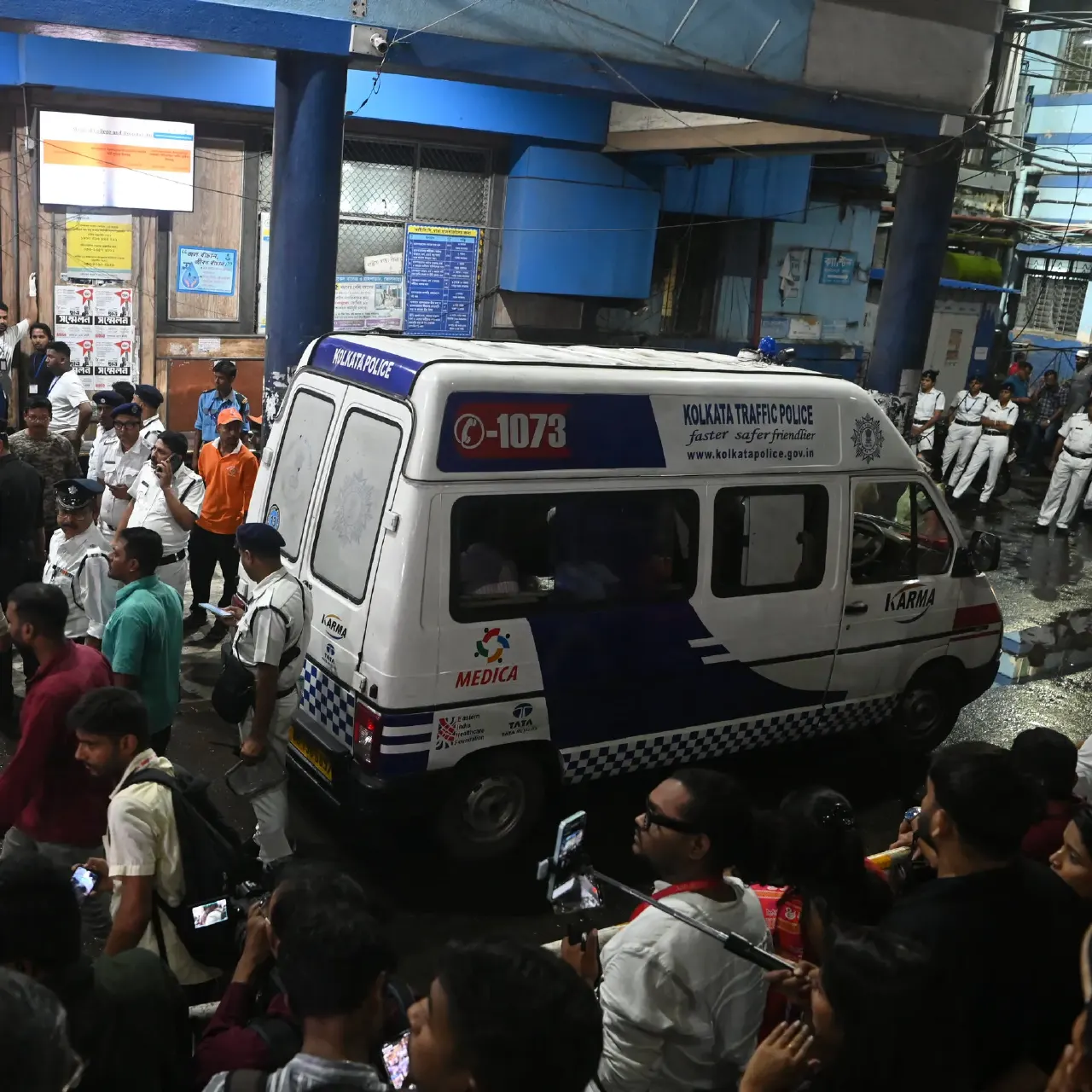 Kolkata Traffic Police ambulance surrounded by police and a crowd at a night scene