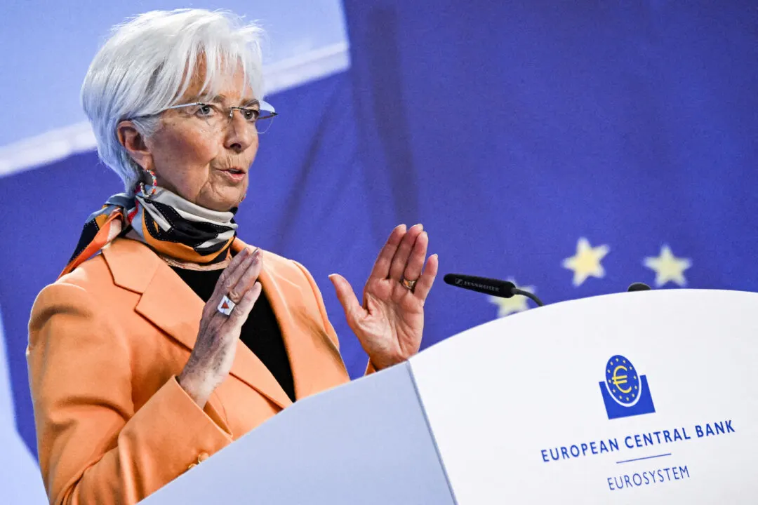Woman with white hair speaking at podium bearing European Central Bank logo, EU flag behind.