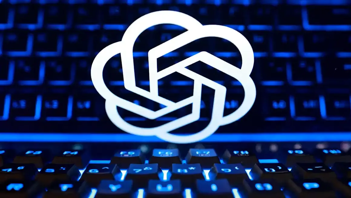 White OpenAI logo glowing above a backlit blue keyboard, photographed up close.