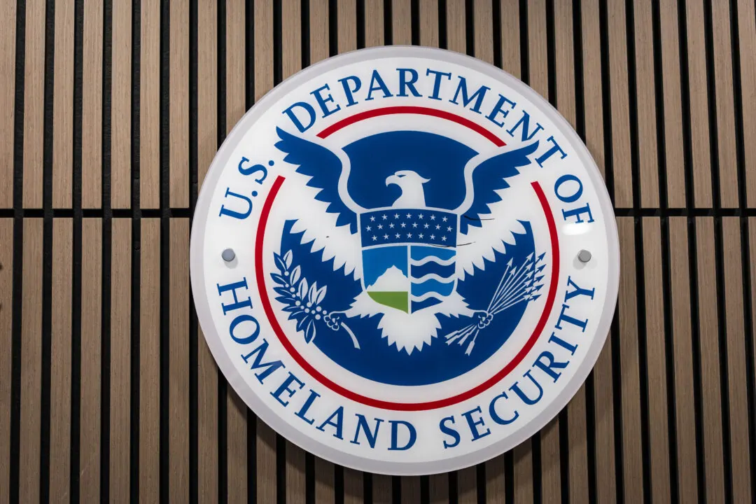 Circular U.S. Department of Homeland Security seal mounted on a wooden slatted wall.