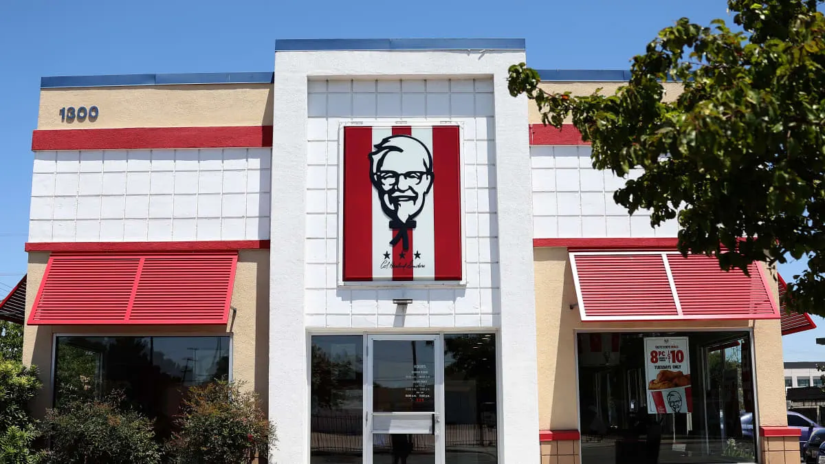 KFC restaurant exterior with large red-and-white Colonel Sanders logo above entrance