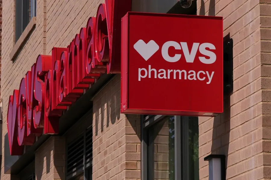 Red CVS Pharmacy sign and logo on a brick building facade, with large red lettering.