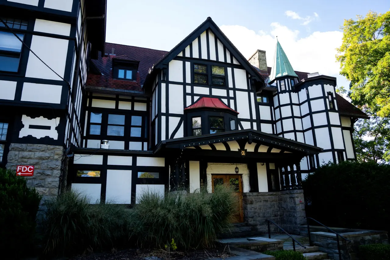 Half-timbered Tudor-style fraternity house with red sign reading FDC, no people visible.