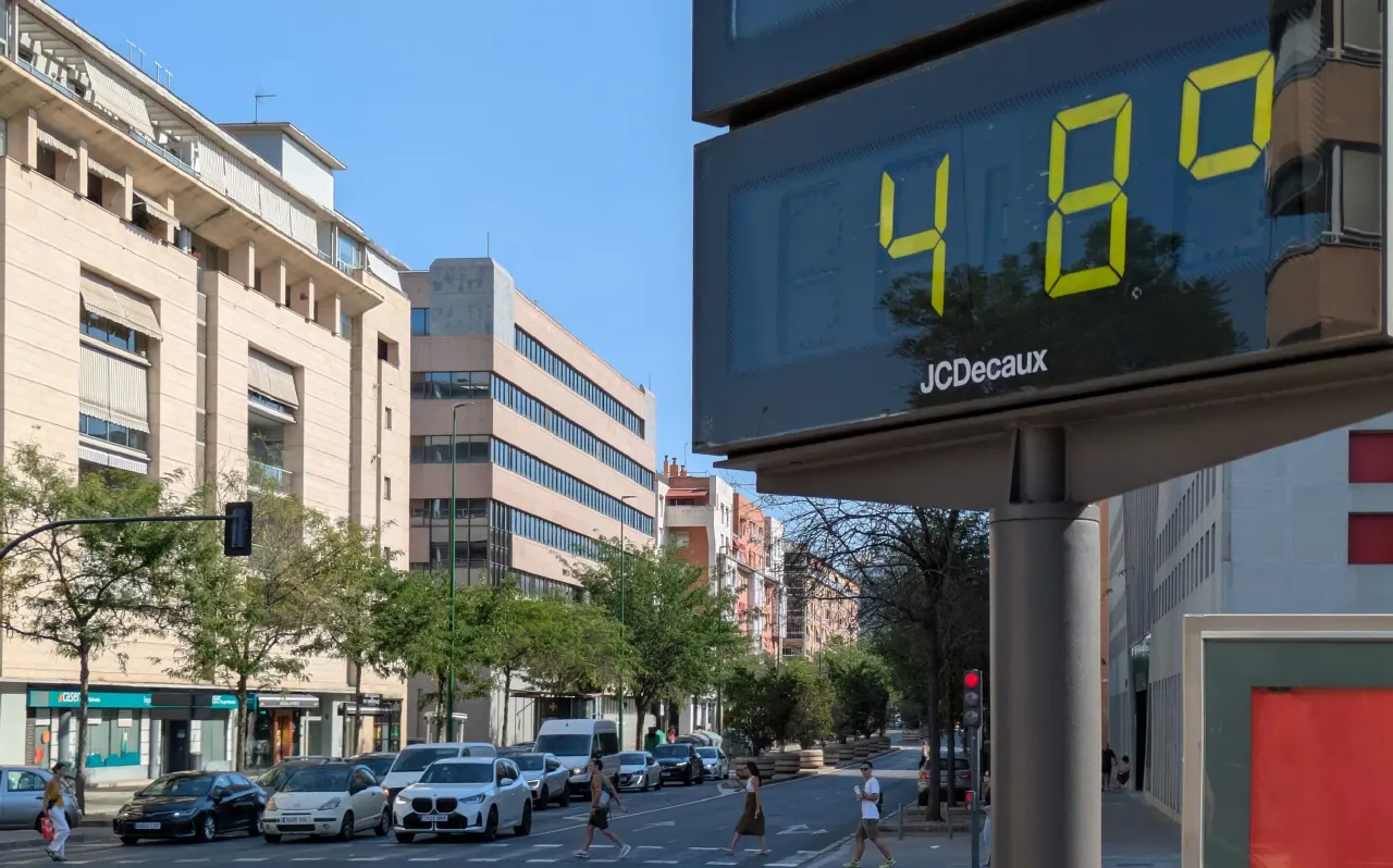 Street scene with a large roadside thermometer showing 48 degrees under a clear sky