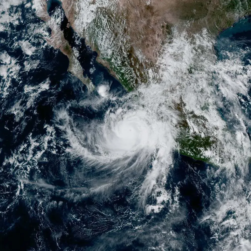 Satellite view of a swirling hurricane with dense cloud bands off Mexico's Pacific coast.