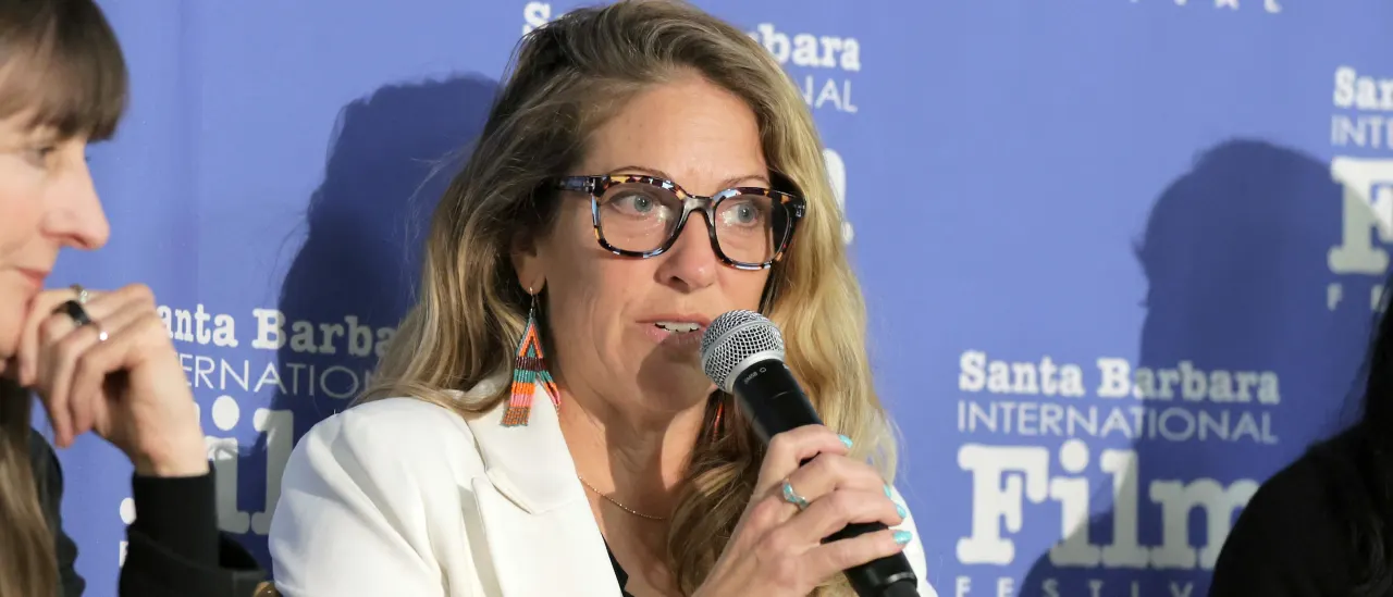 Woman with glasses speaking into microphone at Santa Barbara International Film Festival panel