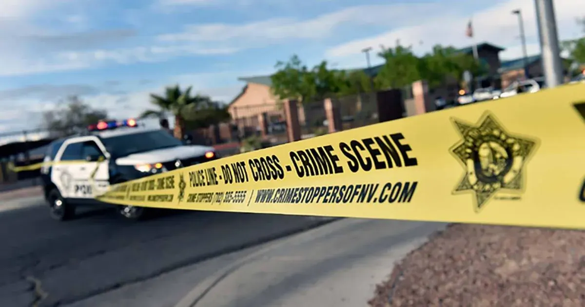Yellow police crime scene tape in foreground with police SUV and building behind.