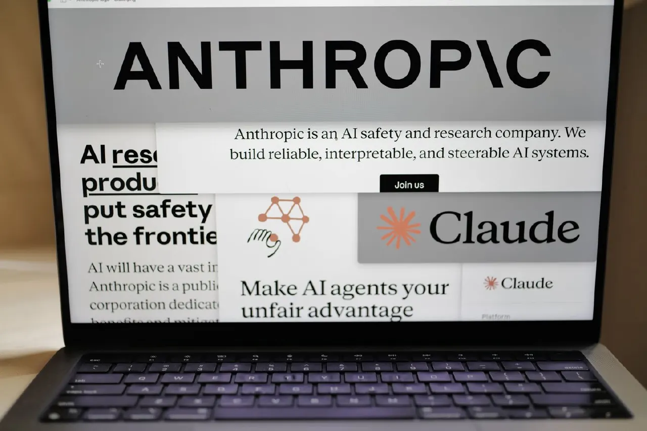 Laptop screen showing Anthropic website with ANTHROPIC wordmark and Claude logo and branding