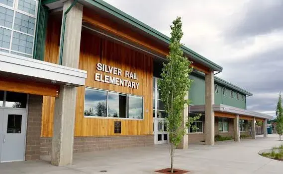 Exterior of Silver Rail Elementary School, wood-clad building with sign and young tree.