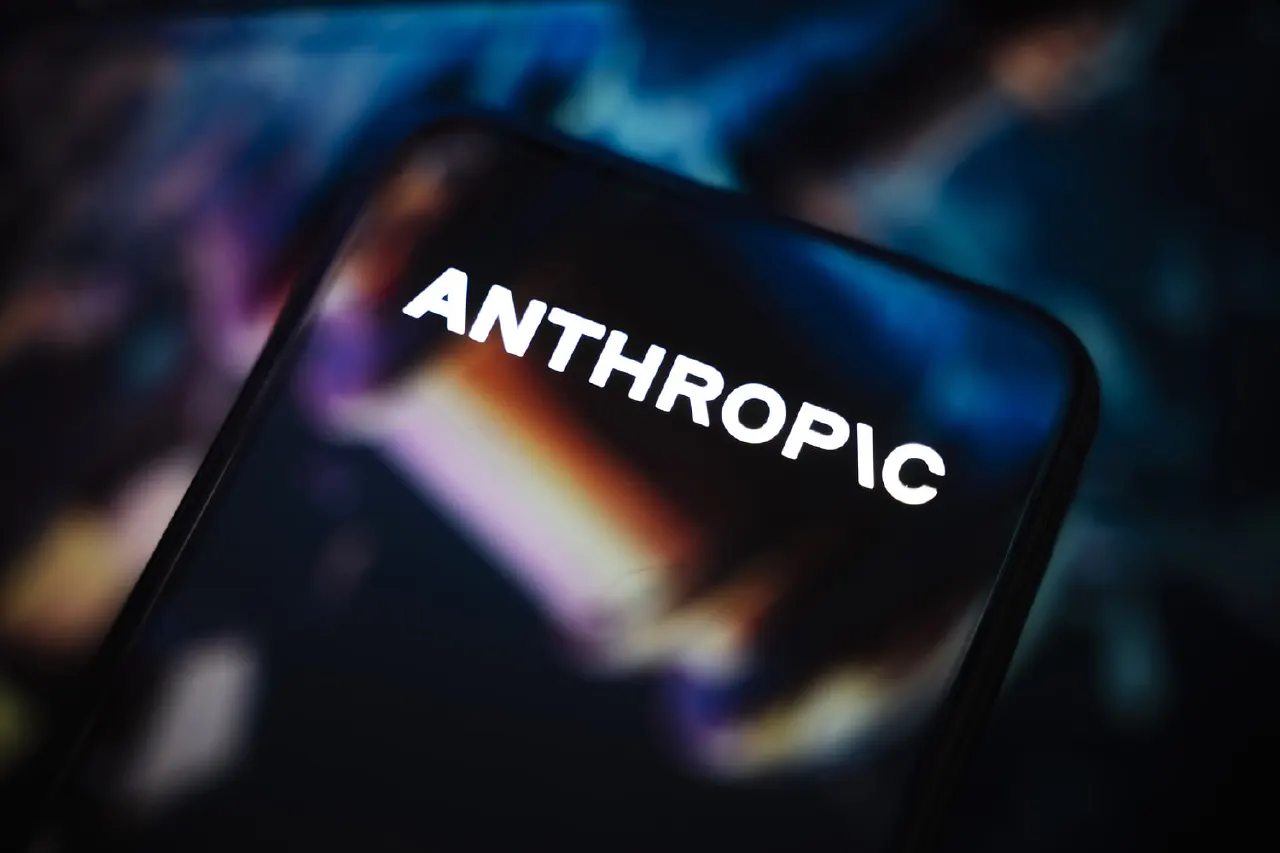 Smartphone screen displaying the Anthropic wordmark against a blurred colorful background.