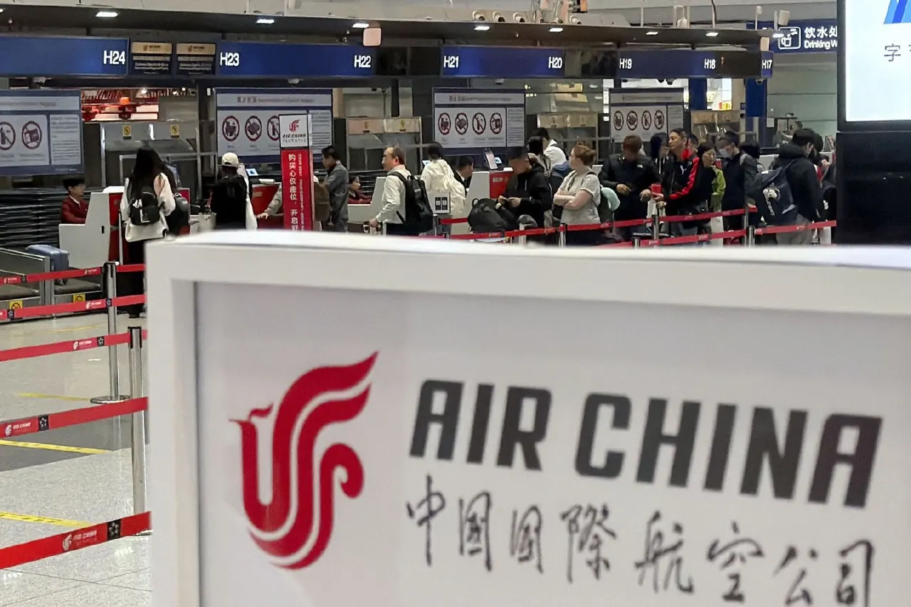 Air China check-in counters at an airport, with travelers queuing behind a red-logo sign.