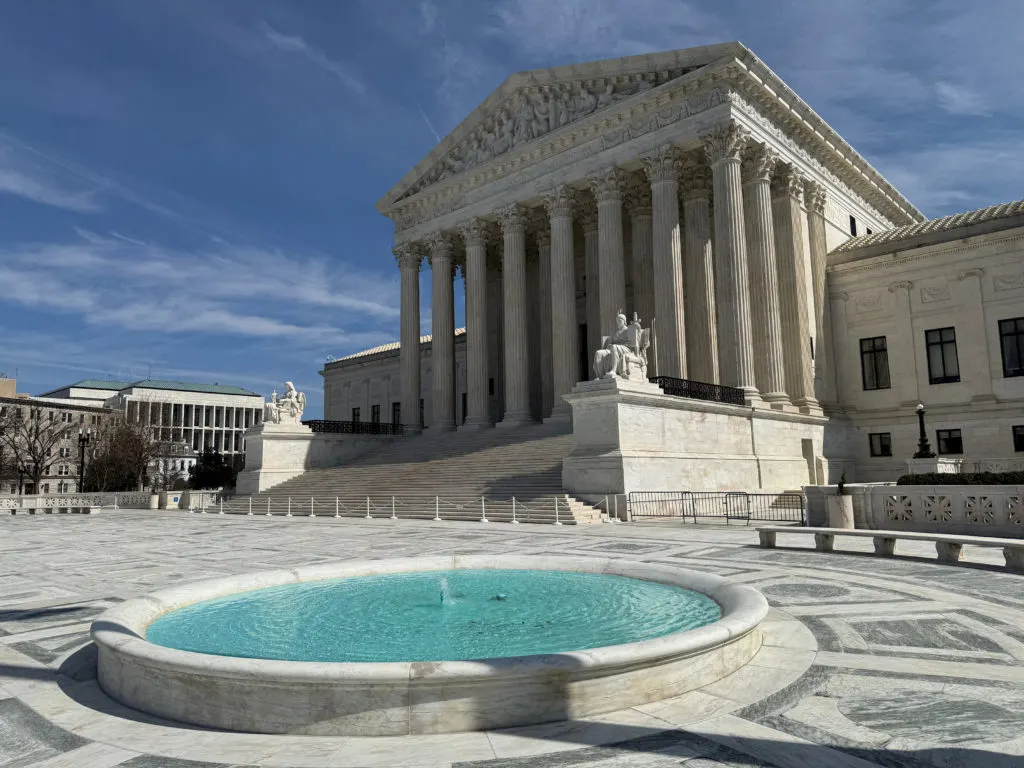 U.S. Supreme Court building exterior with classical columns and fountain.