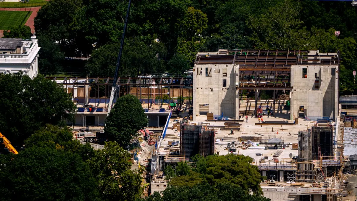 Aerial view of White House ballroom construction site with steel framing, concrete walls, and cranes.