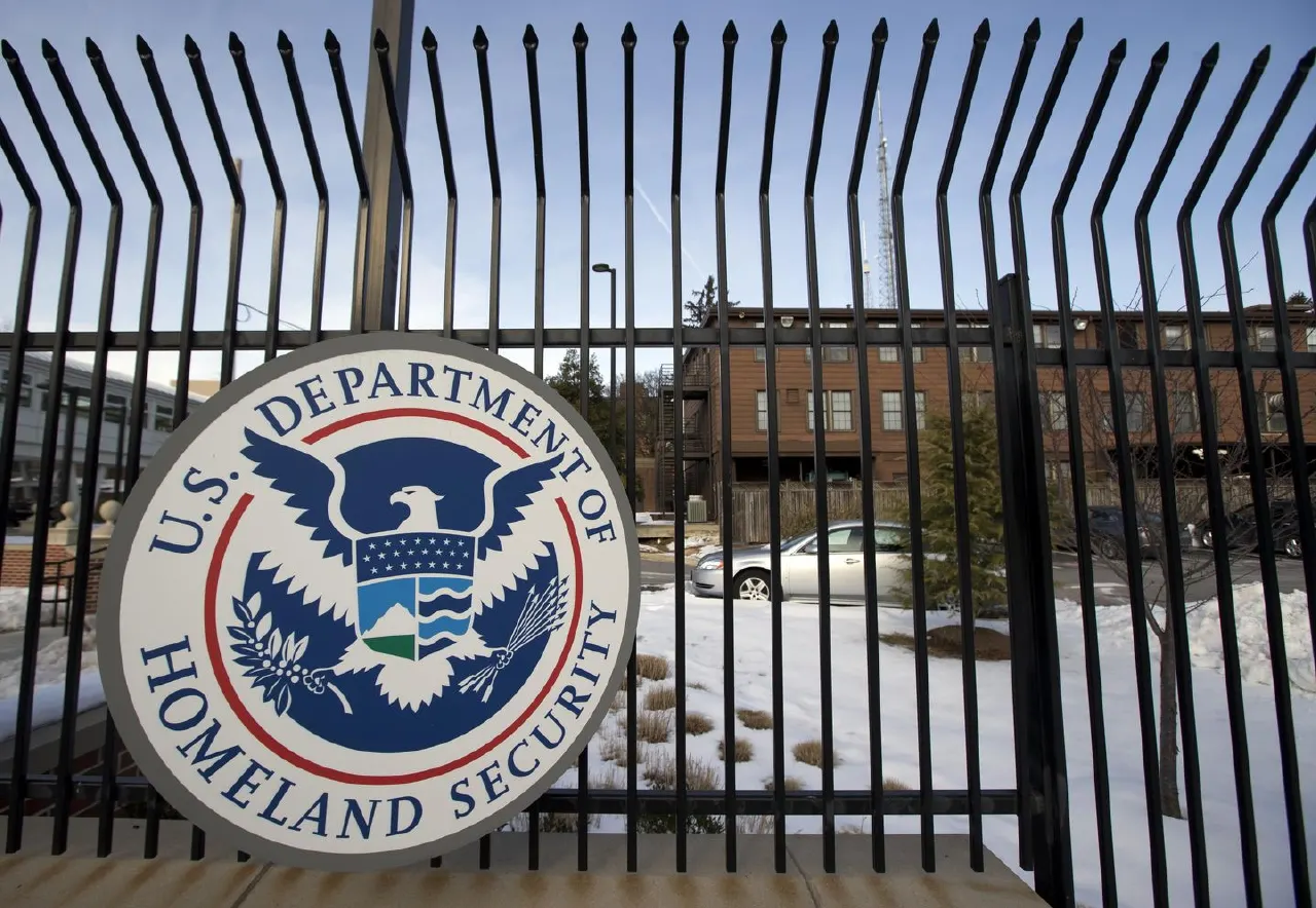 Department of Homeland Security seal on a black iron fence, with snowy building behind