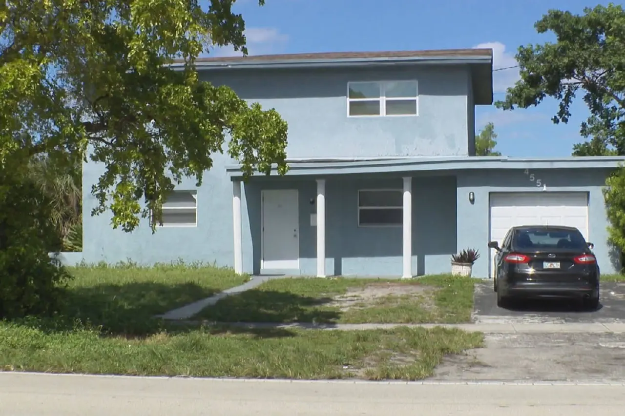 Two-story blue house with a parked dark sedan and house number 551 visible.