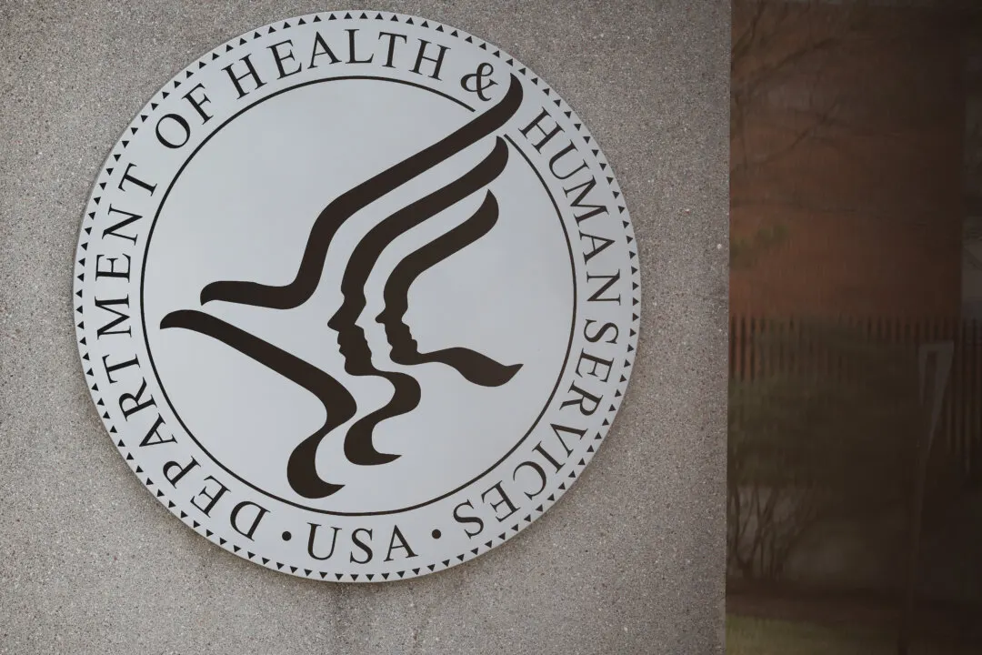 Department of Health and Human Services seal mounted on a concrete wall beside a window.