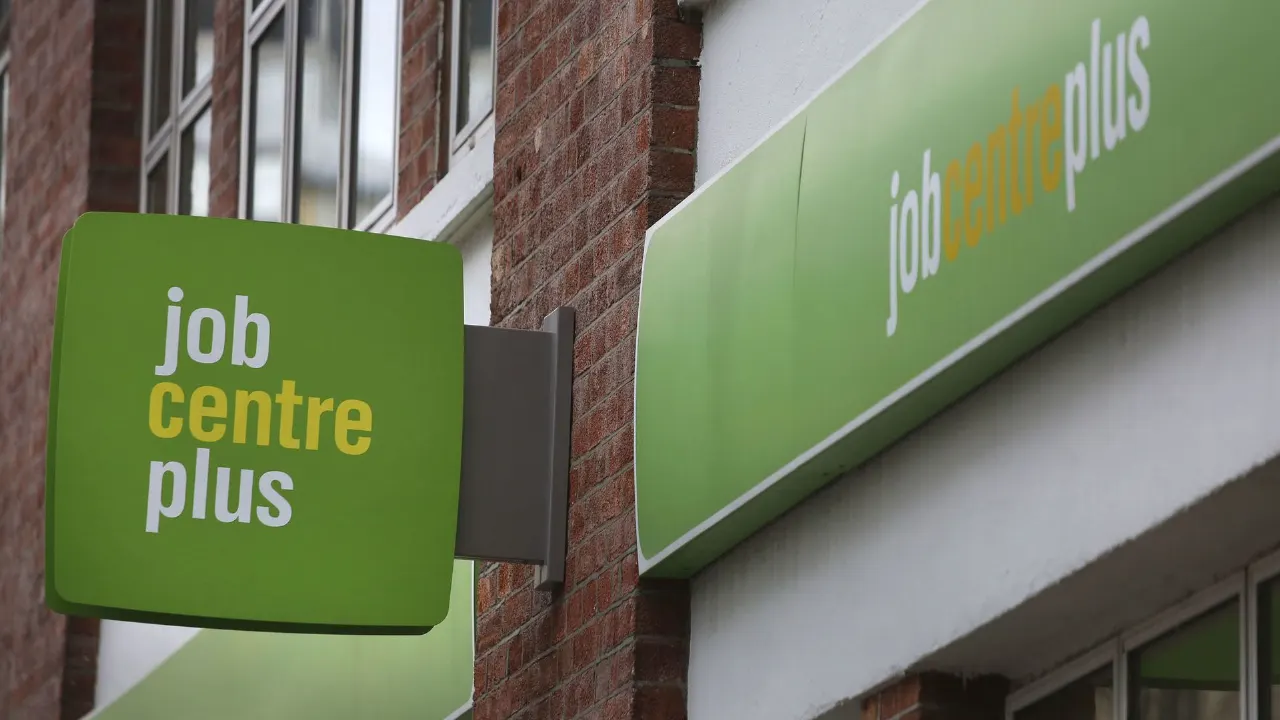 Green Job Centre Plus signs mounted on a brick building facade.