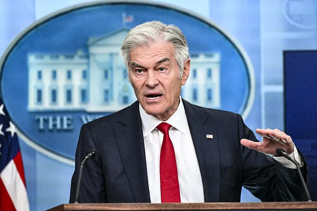 Man in dark suit and red tie speaking at podium before White House briefing room backdrop.