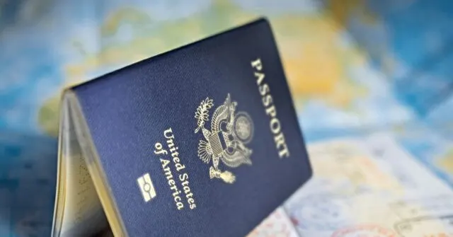 A navy U.S. passport with eagle emblem resting on a blurred world map.