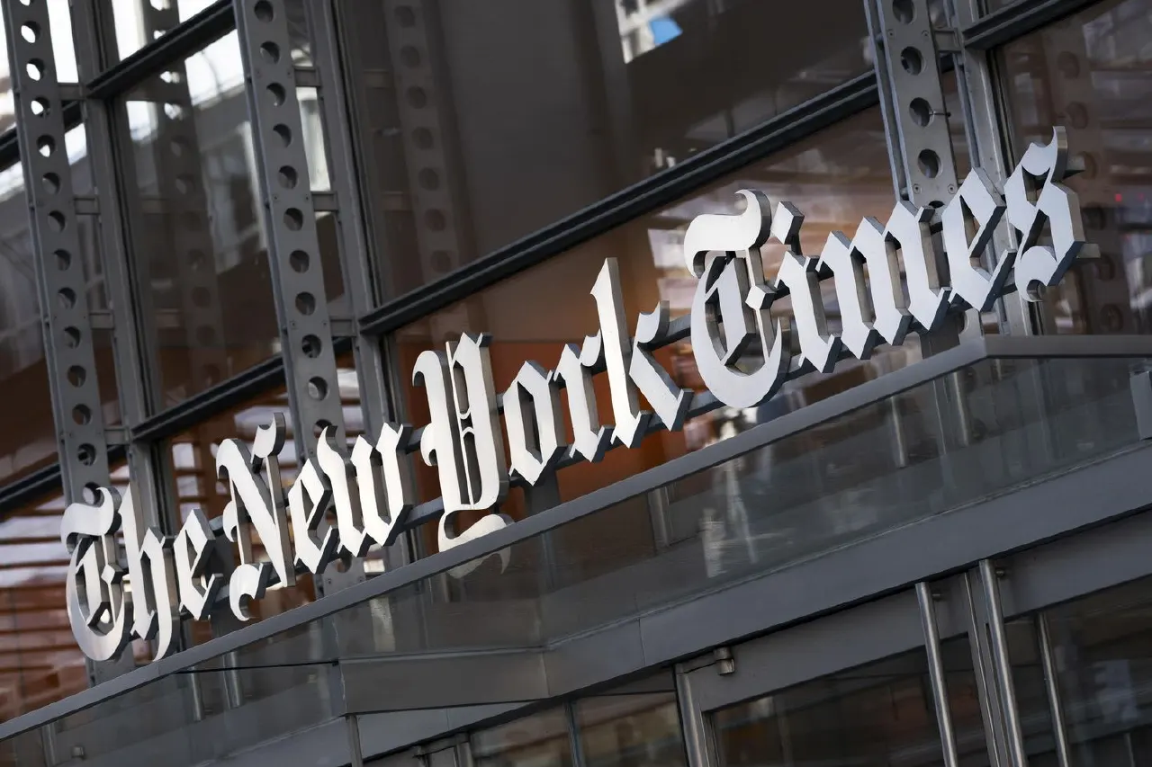 Exterior of a building with 'The New York Times' lettering on a glass facade, angled view.