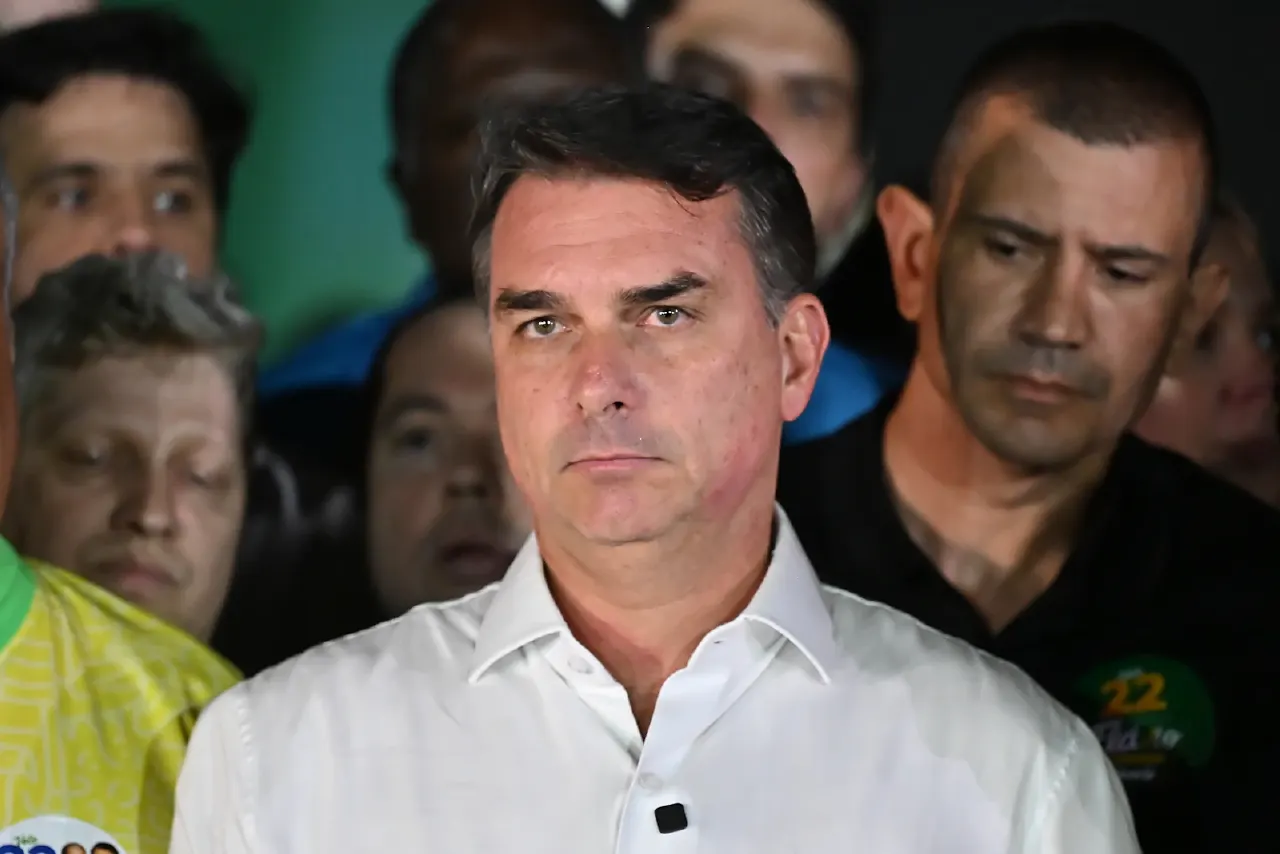Man in white shirt with crowd behind, one wearing black shirt with green campaign-style logo.