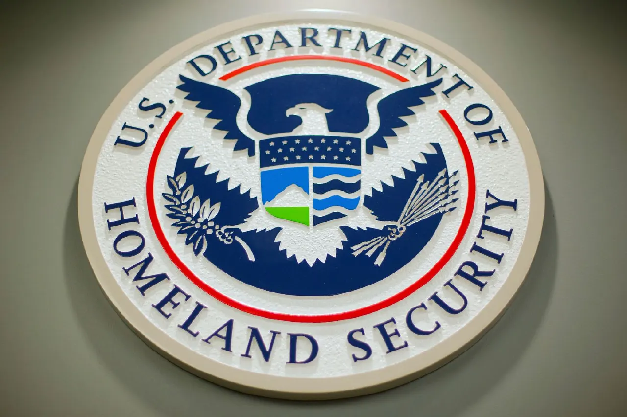 Carved seal of the U.S. Department of Homeland Security mounted on a grey wall