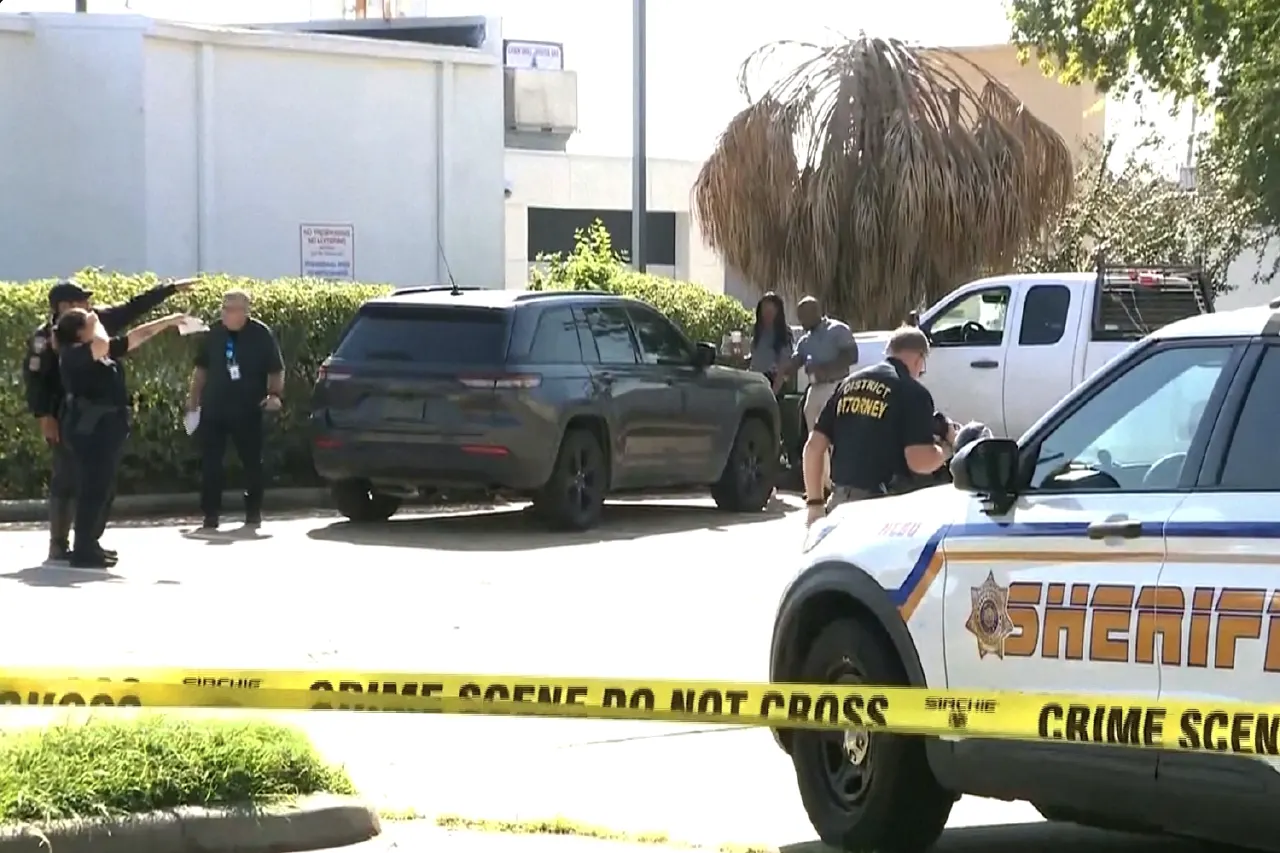 Sheriff's crime scene tape and officers, one wearing a District Attorney jacket, near a parked SUV.